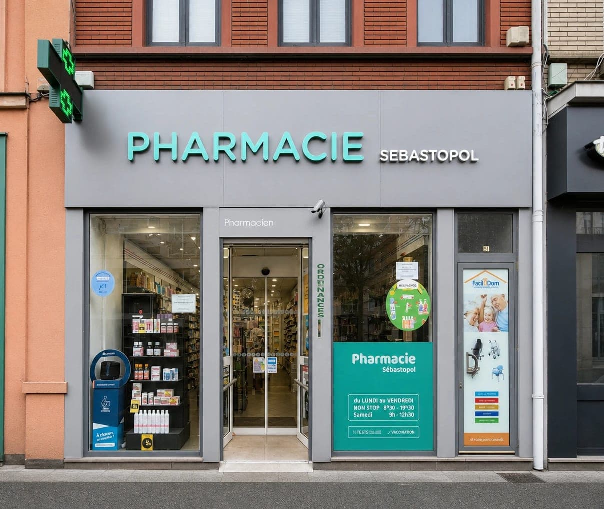 Façade de la Pharmacie Sébastopol au 51 rue des Postes à Lille : brique rouge à l'étage, bandeau avec l'enseigne « Pharmacie Sébastopol » et croix de pharmacie au-dessus de la vitrine.