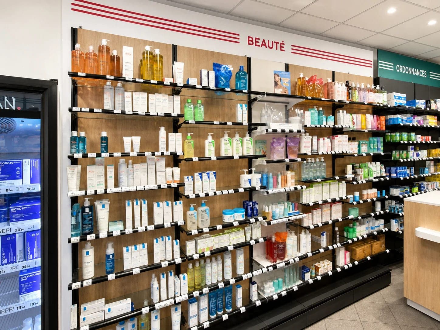 Le rayon Beauté de la Pharmacie Sébastopol à Lille : étagères en bois de dermo-cosmétique et, au fond, l'espace Ordonnances.